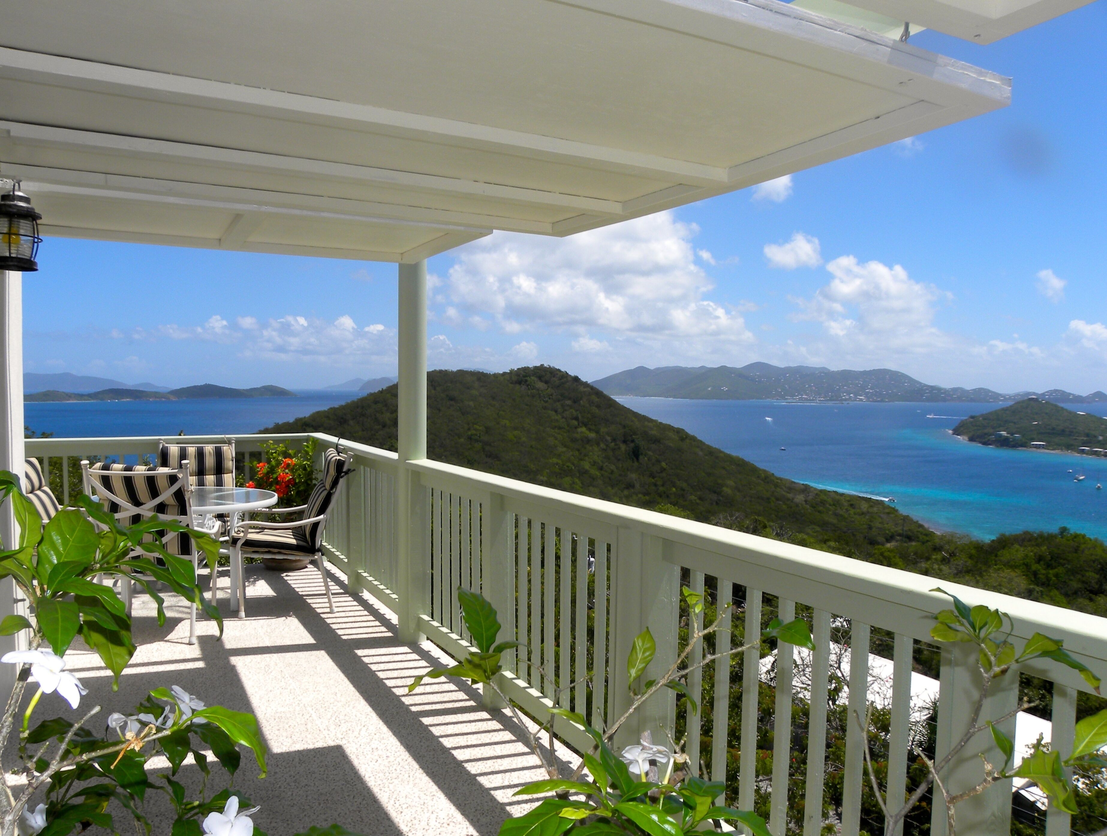 Un balcon avec vue sur la mer et les collines.