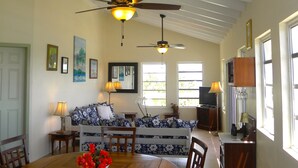 A dining area with a wooden table, chairs, and a ceiling fan. - Brigadoon: A beautiful Villa In Red Hook sleeps 6 studio is available to rent 2 (St. Thomas)