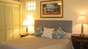 A bedroom with a bed, a ceiling fan, a painting, and two bedside lamps. - Brigadoon: A beautiful Villa In Red Hook sleeps 6 studio is available to rent 2 (St. Thomas)