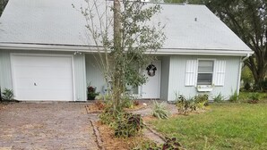 A single-story house with a brick driveway leading to a white garage door. - 2 kitchens, Canoe, kayak on Sunset Lake + 700sqf apt Perfect for family getaways (Odessa)