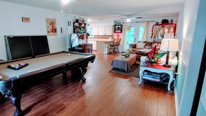 A living room with a pool table, a sofa, a coffee table, and a TV. - 2 kitchens, Canoe, kayak on Sunset Lake + 700sqf apt Perfect for family getaways (Odessa)