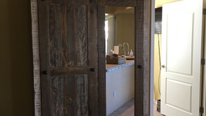 A rustic wooden wardrobe with a star decoration above it, a striped bag, and a tiled floor. - NEW! Luxury Lakefront Estate with Pool and Putting Greens (Glendale)