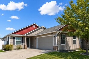 Ein zweistöckiges Haus mit rotem Dach, beige Farbe und einer Garage.