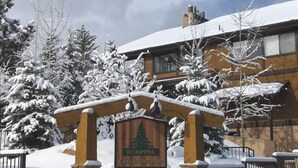 A snow-covered entrance with a wooden archway and a sign for 'Redpine Clubhouse'.