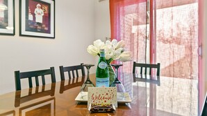 A dining table with a welcome card, a bottle of Spellegrin, and two wine glasses. - Fenced Yard | Open Concept | Near The Village (Meridian)