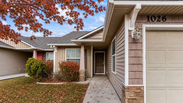 A residential house with a garage, number 1026, a front door, and a small front yard with a lawn and bushes. - Fenced Yard | Open Concept | Near The Village (Meridian)