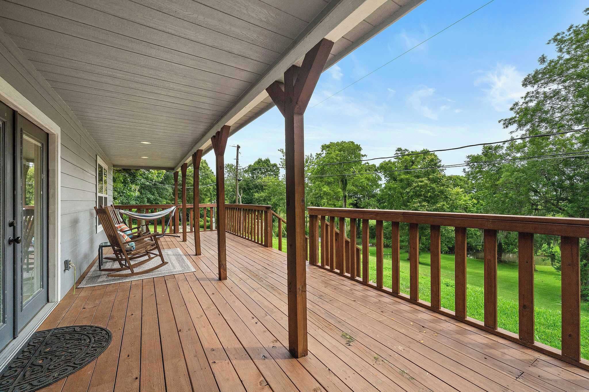 Porch Paradise: Sip drinks on the spacious deck with serene views of lush greenery!