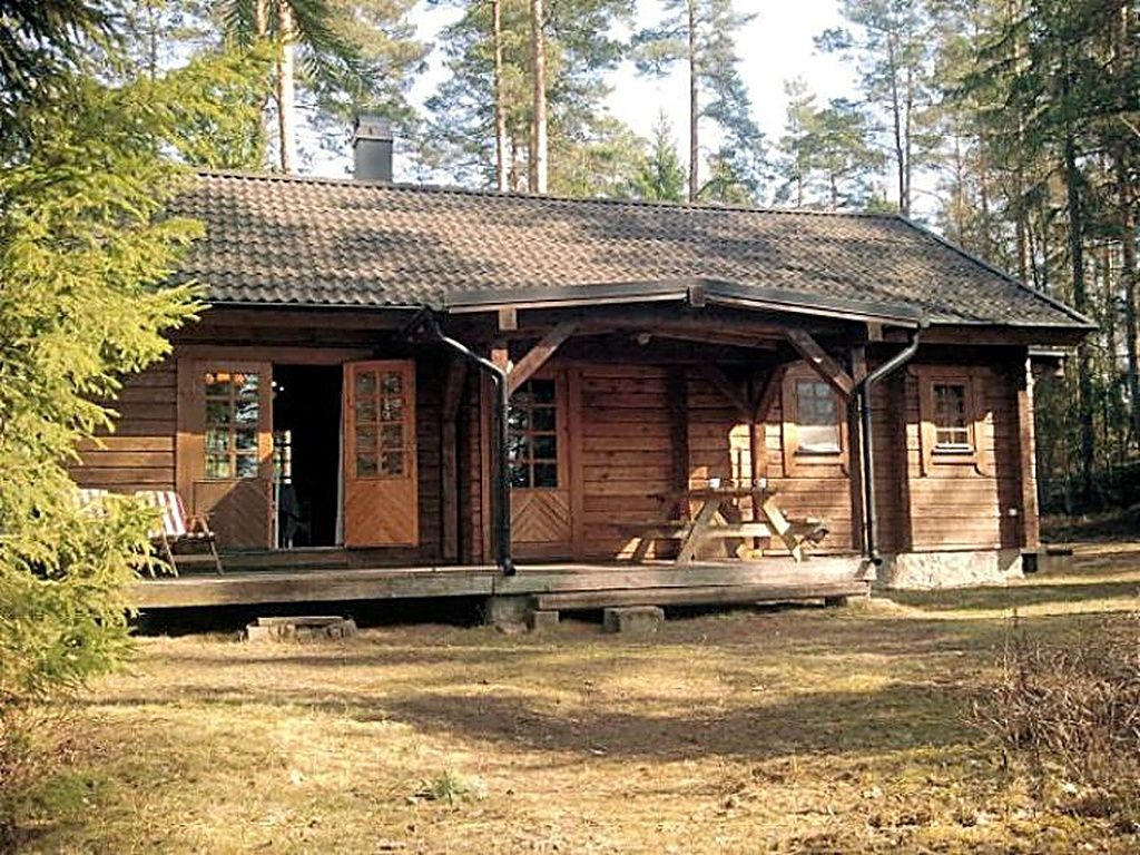 Un chalet rustique doté d’une véranda et d’une table de pique-nique.
