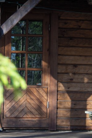 A wooden cabin with a large window and a chevron-patterned door.