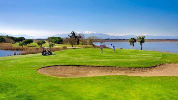 A golf course with a water body, trees, and distant mountains. - Cosy air-conditioned vacation home by the sea, free bikes (Saint-Cyprien)