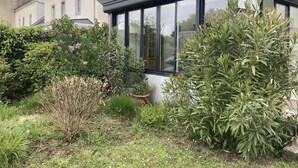 A modern house with a conservatory, surrounded by lush greenery and a well-maintained garden. - Le cottage de Soiz vacation rental  (Bannalec)