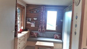 A cozy room with a wooden bench, a window with curtains, a wall clock, and a bulletin board with papers. - 3 * appt, 5 people in the heart of the resort, open to hikers out of season (Les Avanchers-Valmorel)