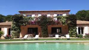 Un edificio di due piani con una piscina di fronte.