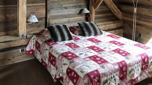 A rustic wooden room with a bed, a lamp, and a heater. - Alpine chalet, near ski resort, for 10 people, completely renovated. (Montgellafrey)