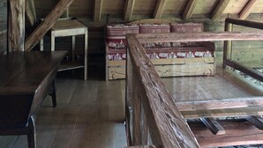 A rustic wooden room with a sloped ceiling, a wooden bench, a table, and a patterned sofa. - Alpine chalet, near ski resort, for 10 people, completely renovated. (Montgellafrey)