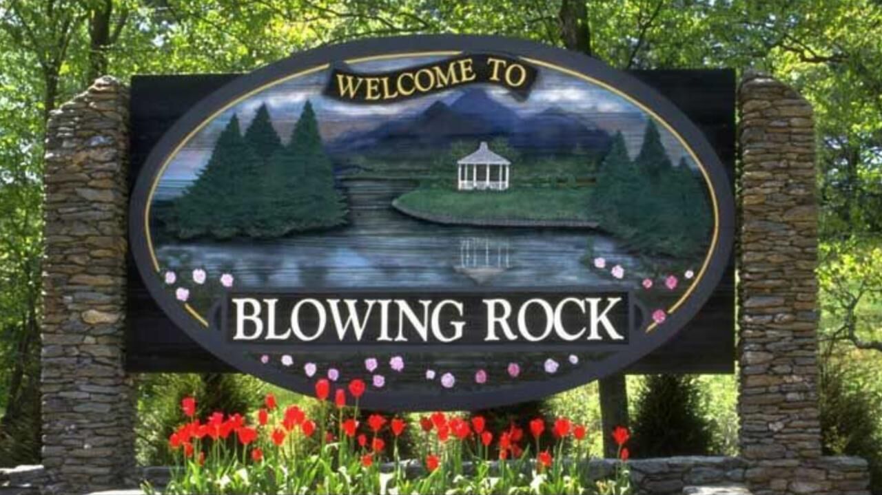 A welcome sign for Blowing Rock with a scenic lake and trees.