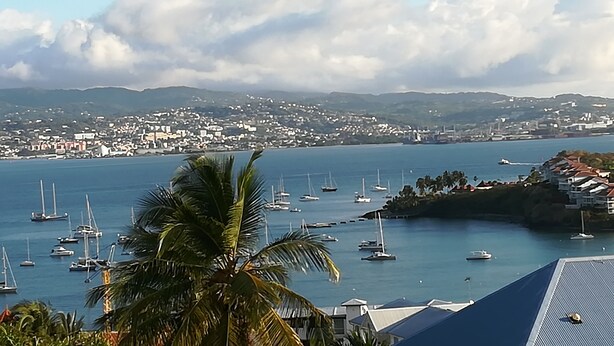 A coastal town with a marina filled with sailboats, surrounded by hills and residential buildings. - STUDIO ANSE MITAN TROIS ILETS MARTINIQUE (Trois Ilets)