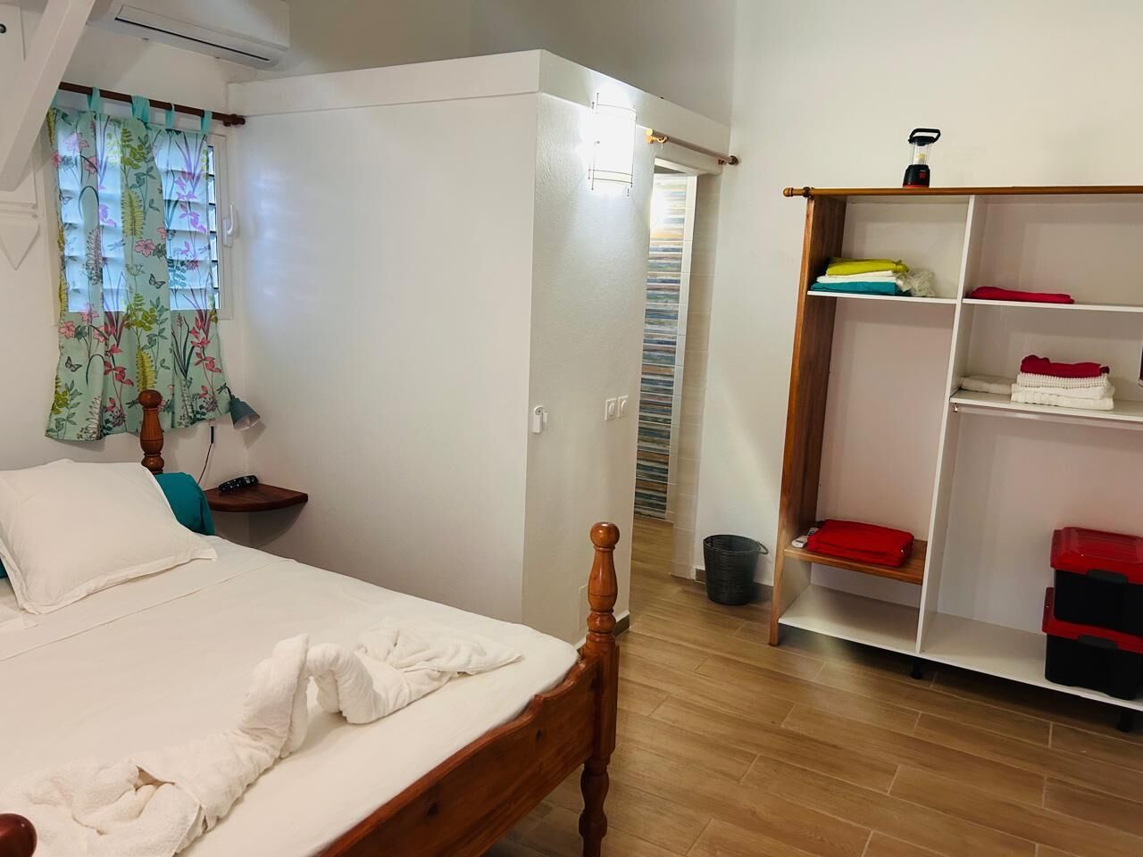 A bedroom with a wooden bed, a wardrobe, and a shelf unit.
