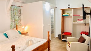Un dormitorio con una cama de madera, una mesita de noche, una silla y un armario.