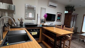 Une cuisine moderne dotée d’un plan de travail en bois, d’un four encastré et d’un coin repas avec une table et des chaises en bois.