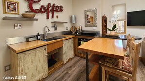 Une cuisine moderne dotée d’un plan de travail en bois, d’un évier et d’un coin repas avec une table et des chaises.
