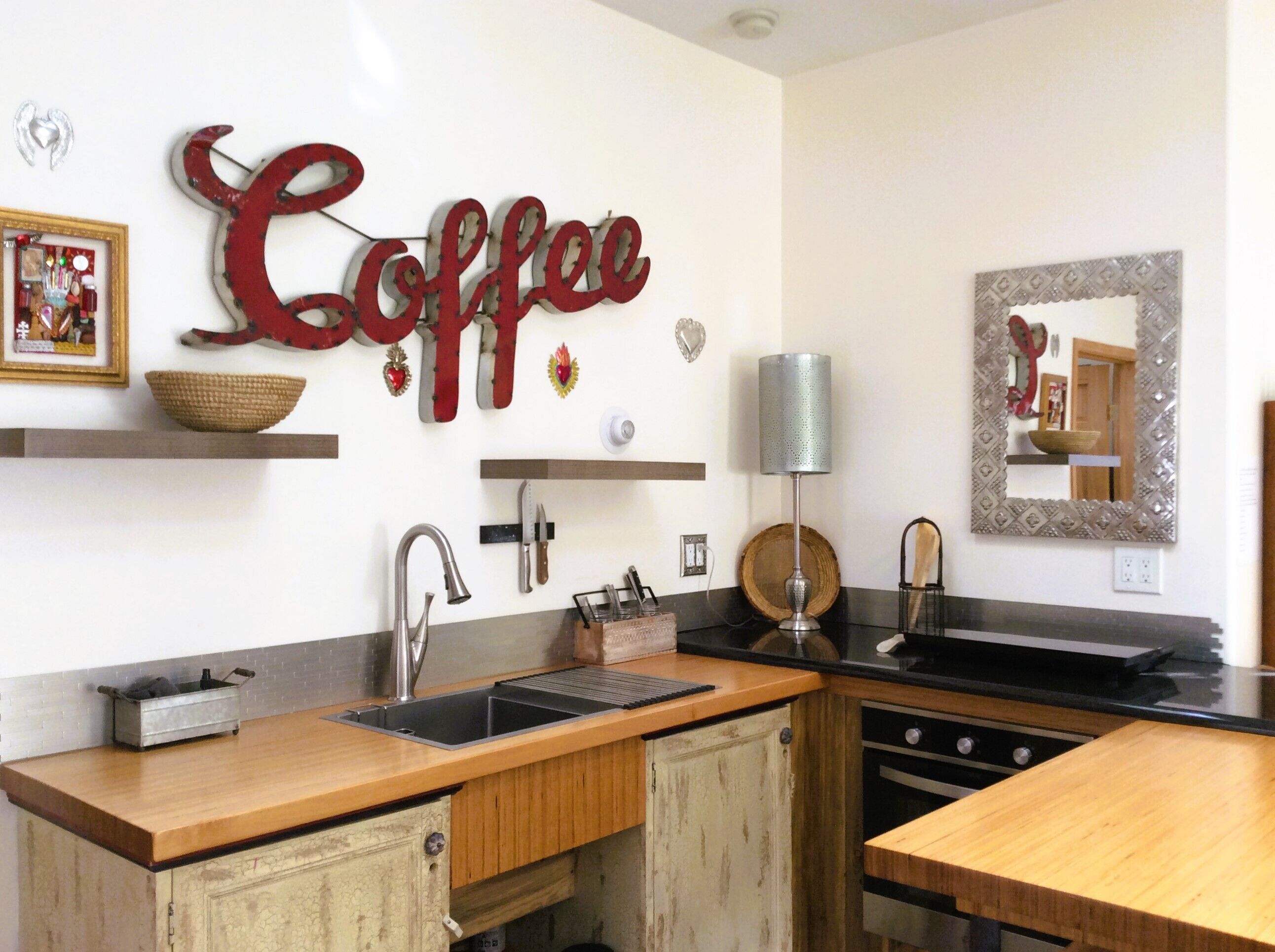 Una cocina con encimera de madera, un lavabo y un adorno mural con temática de café.