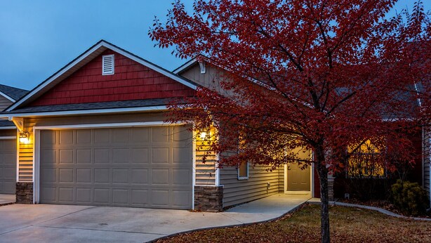 A residential house with a garage, a driveway, and a tree with red leaves. - Fenced Yard | Updated Kitchen | Quiet Neighborhood (Meridian)