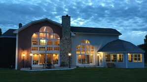 A large house with a stone chimney, large arched windows, and a small attached structure. - Walk to Drakes Island Beach, Large Kitchen & Yard, Theater & Gym! Very Private (Wells)
