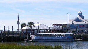 A waterfront restaurant with a docked boat and a building with a sign that reads "Wicked Dog." - Sandy Feet Retreat-1/2 Block to Beach, Pet Friendly, Wi-Fi & Optional GC Rental  (Surfside Beach)