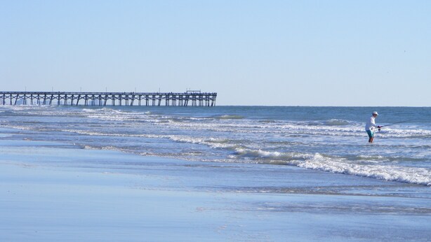 A beach with a pier extending into the ocean. - Sandy Feet Retreat-1/2 Block to Beach, Pet Friendly, Wi-Fi & Optional GC Rental  (Surfside Beach)