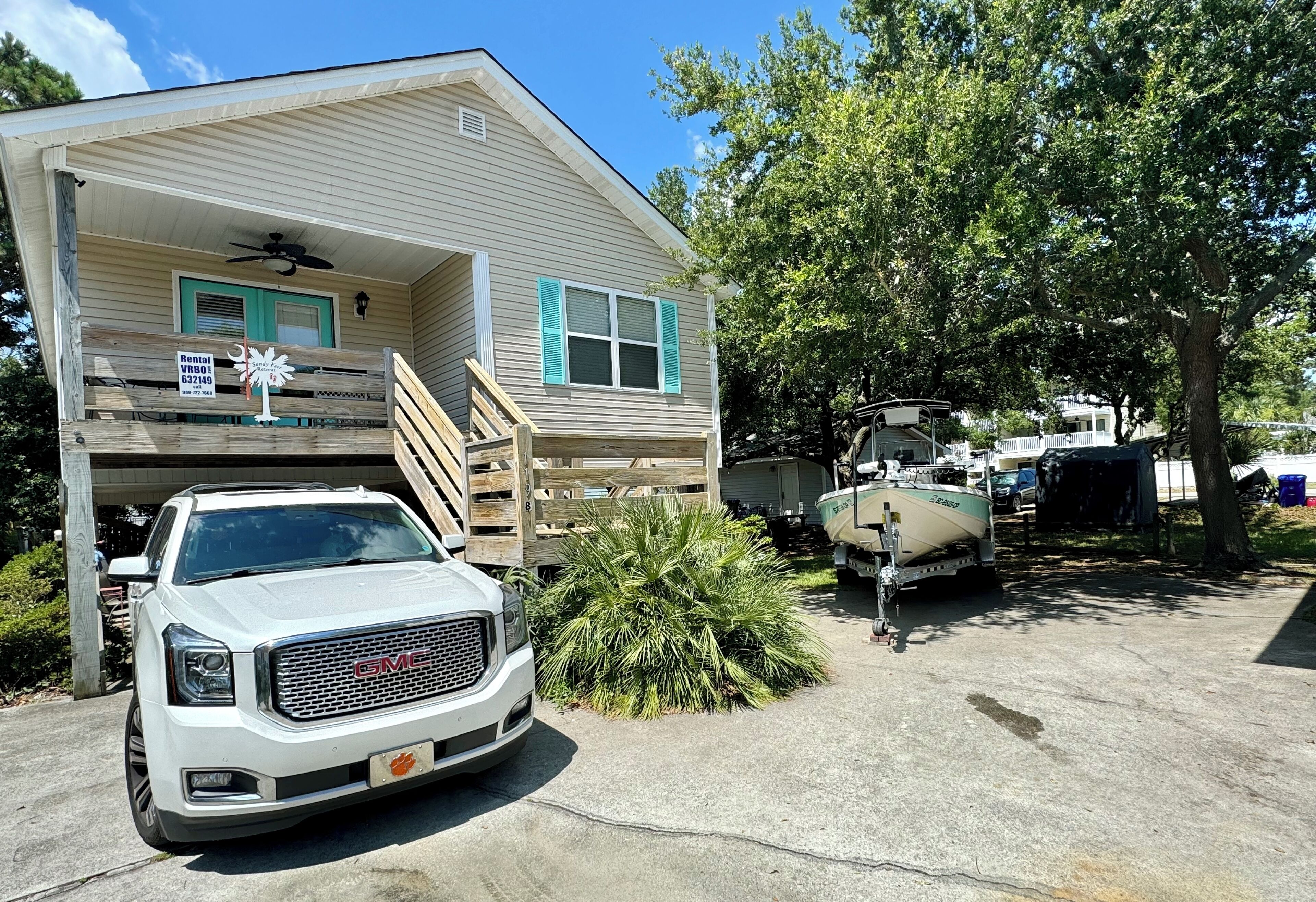 Une maison à deux étages avec un porche et un garage. Un camion blanc est garé devant.
