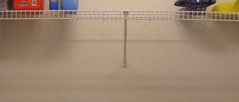 A laundry area with a washing machine, a dryer, and a shelf with cleaning supplies.