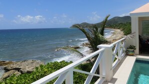 A coastal view with a pool, rocky shoreline, and a white railing. - Relax in Paradise on St. Croix's North Shore - Cane Bay! (Christiansted)