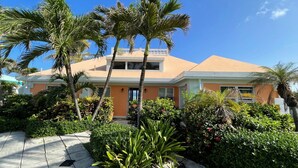 A hotel with a two-story structure, a flat roof, and a well-maintained garden with palm trees and shrubs. - Relax in Paradise on St. Croix's North Shore - Cane Bay! (Christiansted)