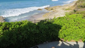A coastal landscape with a sandy beach, rocky shoreline, and green vegetation. - Relax in Paradise on St. Croix's North Shore - Cane Bay! (Christiansted)
