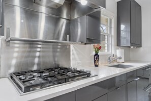 Prepare meals in the fully equipped kitchen with a gas stove, oven, and ample counter space.