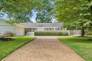 Set amidst mature trees, this single-story house offers a serene natural setting with a driveway and well-manicured lawns.