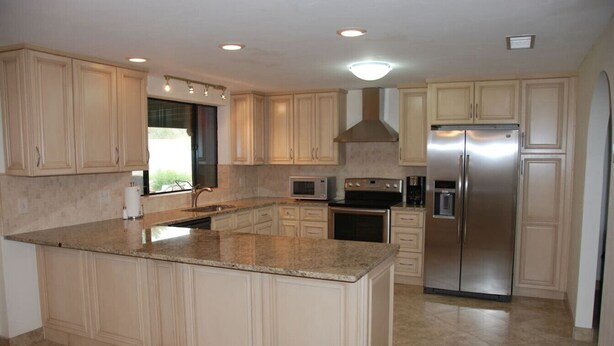 A kitchen with a large island, stainless steel appliances, and light-colored cabinetry. - Wonderful Whispering Hills (Tucson)