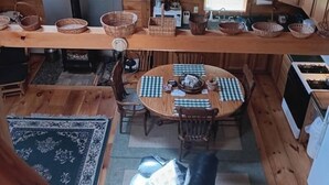 A cozy cabin with a dining area, kitchen, and a large window. - Hand Crafted Log Cabin (St George)