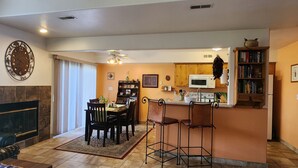 A dining area with a table and chairs, a kitchen with a microwave, and a bookshelf. - Family and Pet Friendly Condominium in Moab by Golf Course  (Moab)