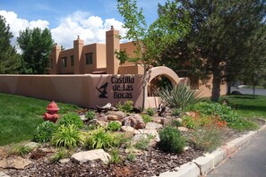 A building with a sign reading "Castillo de las Rocas" and a landscaped garden with rocks and plants. - Family and Pet Friendly Condominium in Moab by Golf Course  (Moab)