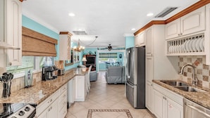 A kitchen with white cabinets, granite countertops, stainless steel appliances, and a tiled floor. - P11 - Charming 2 bedroom 2 bath duplex with private pool and dock - Completely updated. (Marathon)