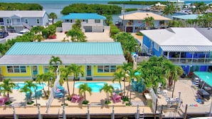 A resort with a pool area, multiple buildings, and a view of the ocean. - P11 - Charming 2 bedroom 2 bath duplex with private pool and dock - Completely updated. (Marathon)