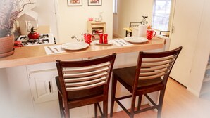 A kitchen with a wooden countertop, two wooden chairs, a stove, and a window. - Secluded rental on 40 acre ranch. (Warner Springs)