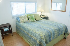 A bedroom with a bed, a nightstand, a lamp, and a window with blinds. - Secluded rental on 40 acre ranch. (Warner Springs)