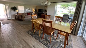 Amplia sala de estar con mesa de comedor, sillas, sofá y televisor.