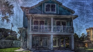 A two-story house with a balcony, a front porch, and a bicycle parked outside. - Steps to the non-driving section of the beach!  (Saint Augustine Beach)