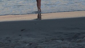 Une personne se tient sur une plage, face à l’océan.