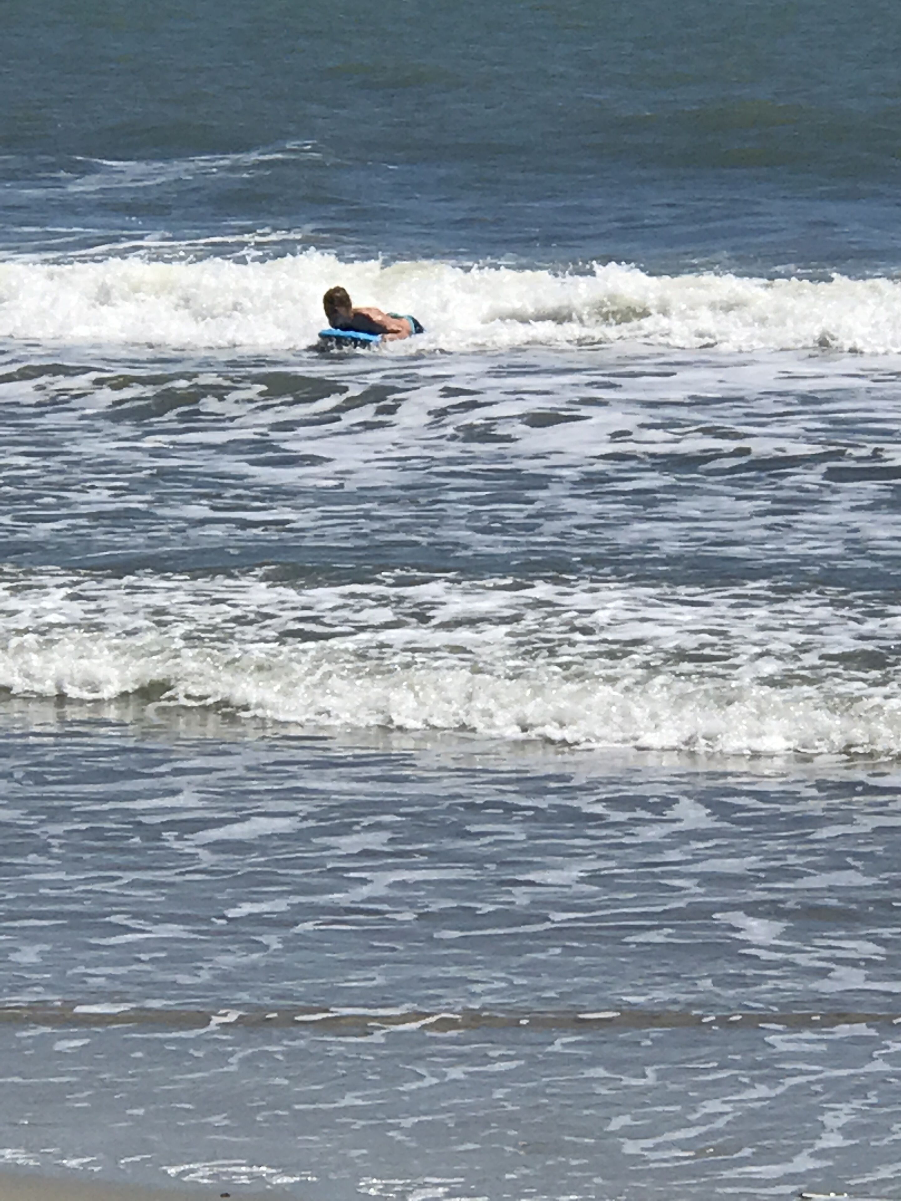 Eine Person im Wasser, möglicherweise in einem See oder Meer, umgeben von Wellen.
