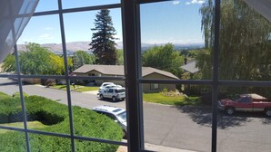 A residential area with houses, parked cars, and a mountain range in the background.